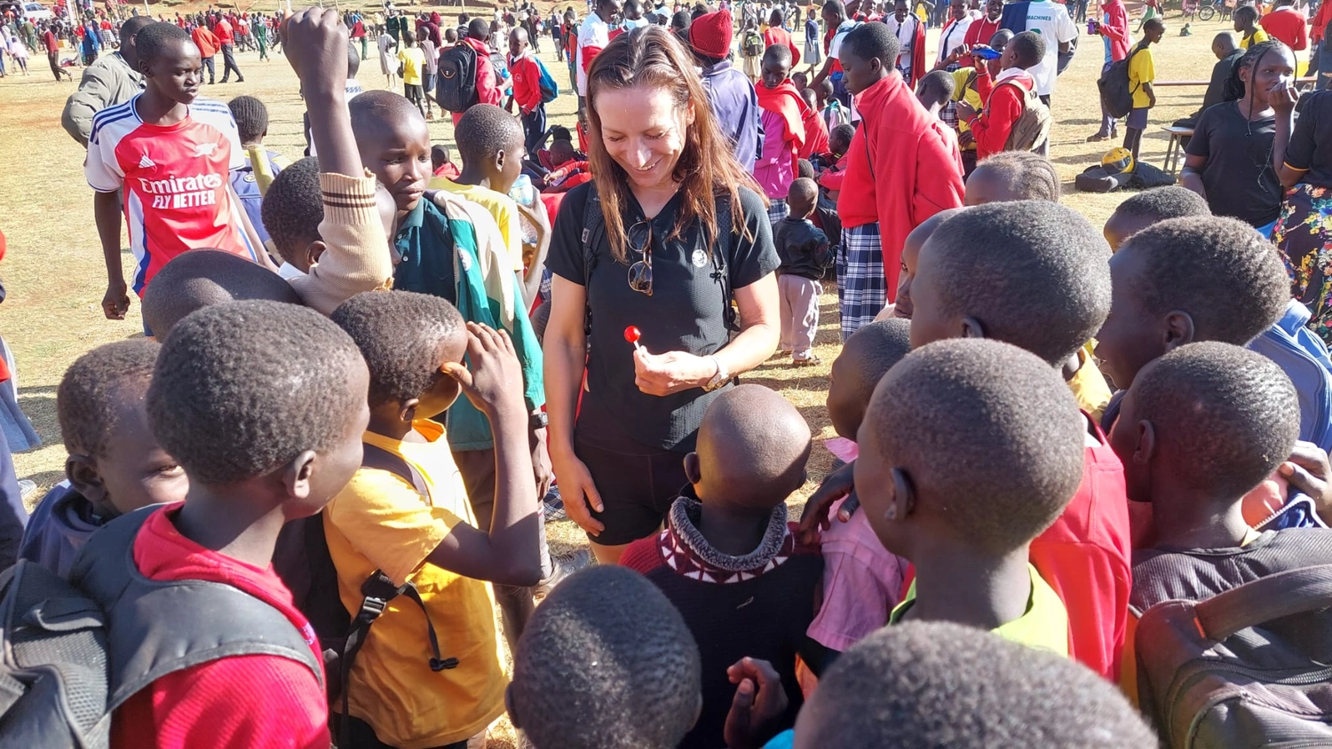 42.195 for Children - a global running initiative - a woman distributing something to children